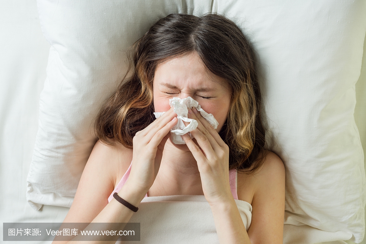 流感季节流感,流鼻涕。生病的女孩在床上用手
