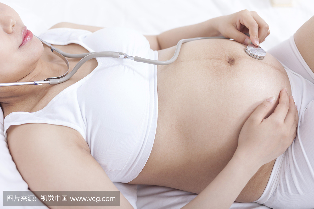 孕妇戴听诊器听胎儿声音