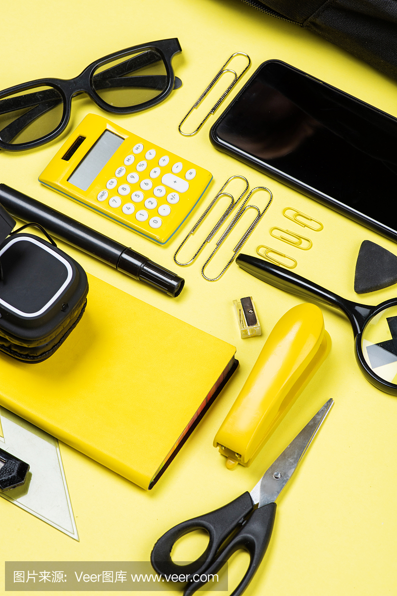 计算器,智能手机和学校用品黄色的特写视图