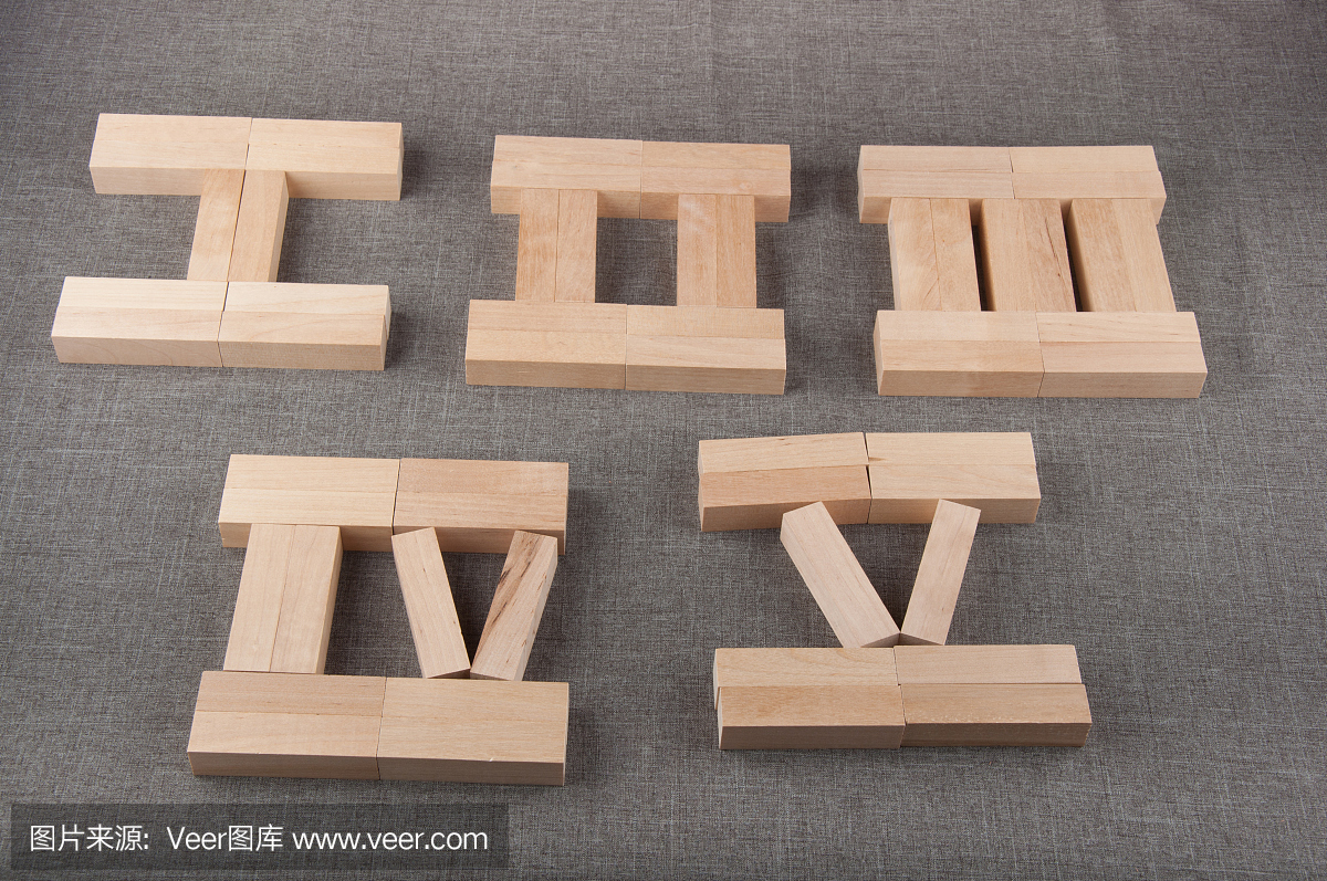 木制的罗马数字由玩具砖制成躺在灰色的织物背