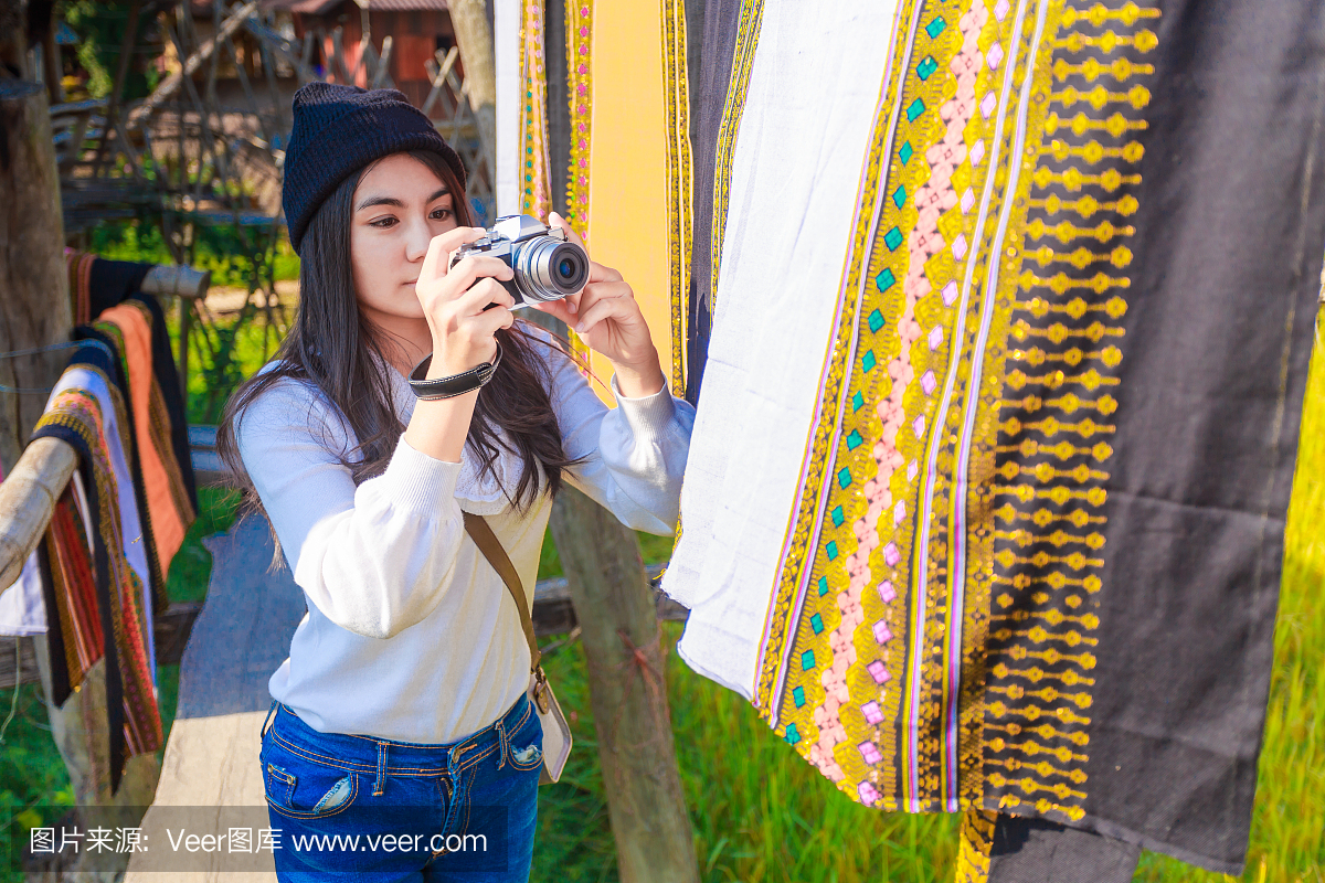 亚洲女人拍照片在风中飘扬的泰国布裙