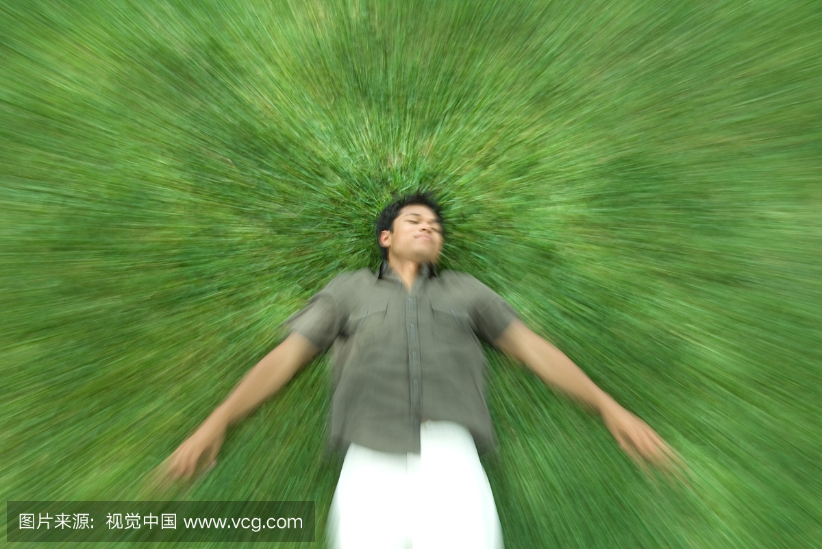 男人躺在草地上闭着眼睛,模糊的动作