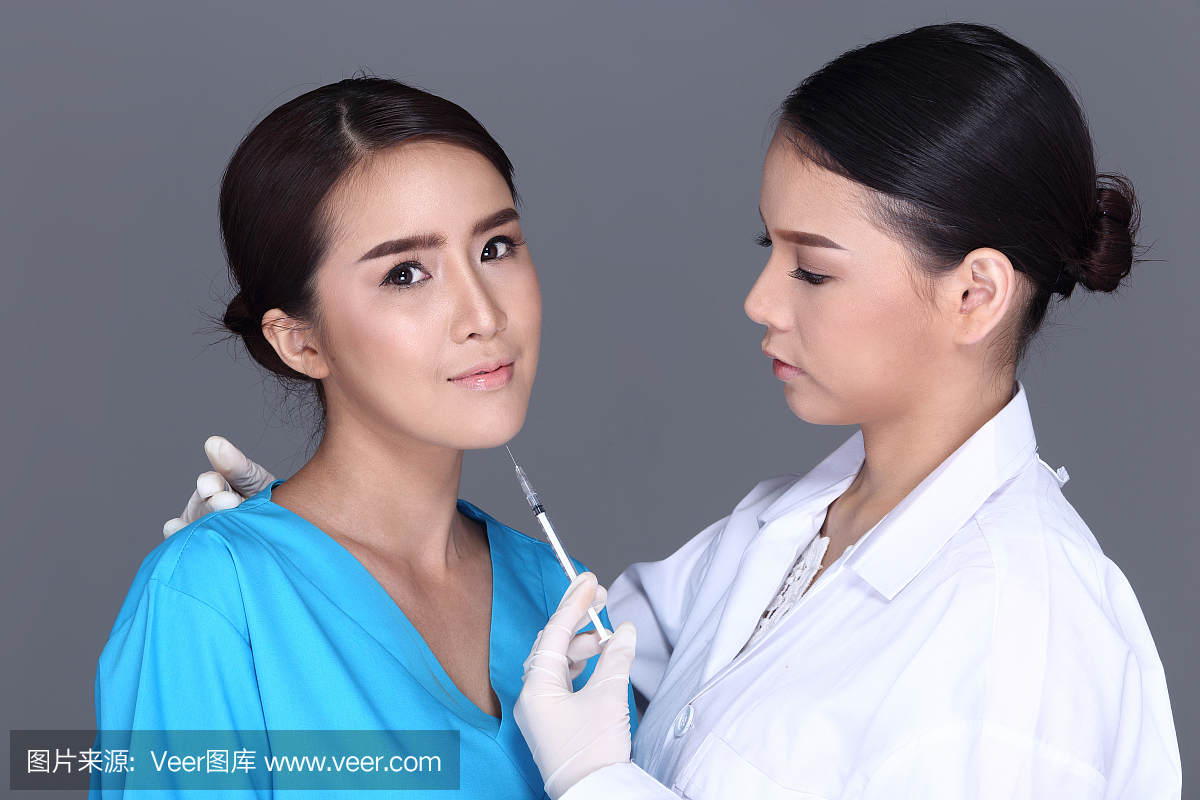 美容师医生在整形手术前将注射器放在面部结构