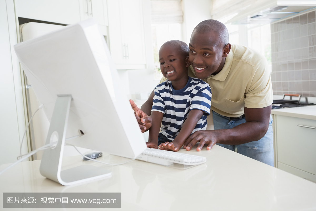 Happy smiling father with his son using comput