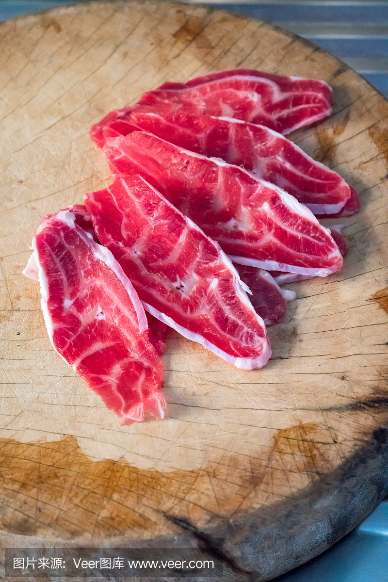 在木砧板上的新鲜切片的牛肉后腿小腿