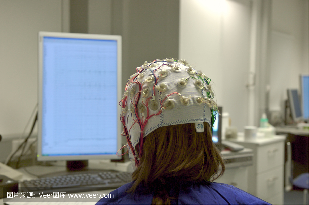 屏幕前方与EEG电缆连接的女孩