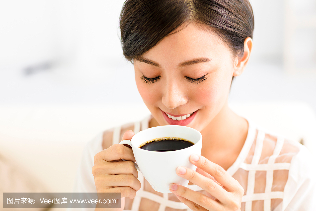 年轻的微笑女人早上喝咖啡