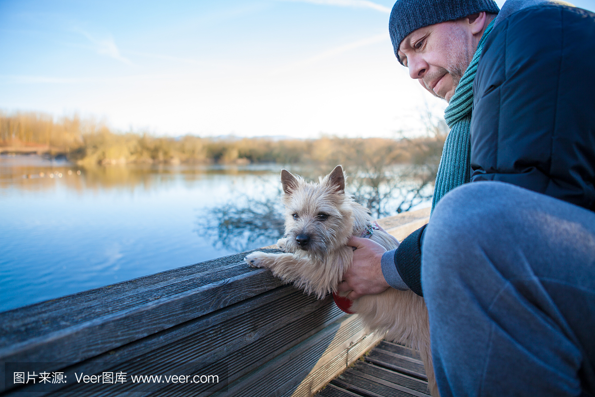 有一只小狗的人在湖上的凯恩梗