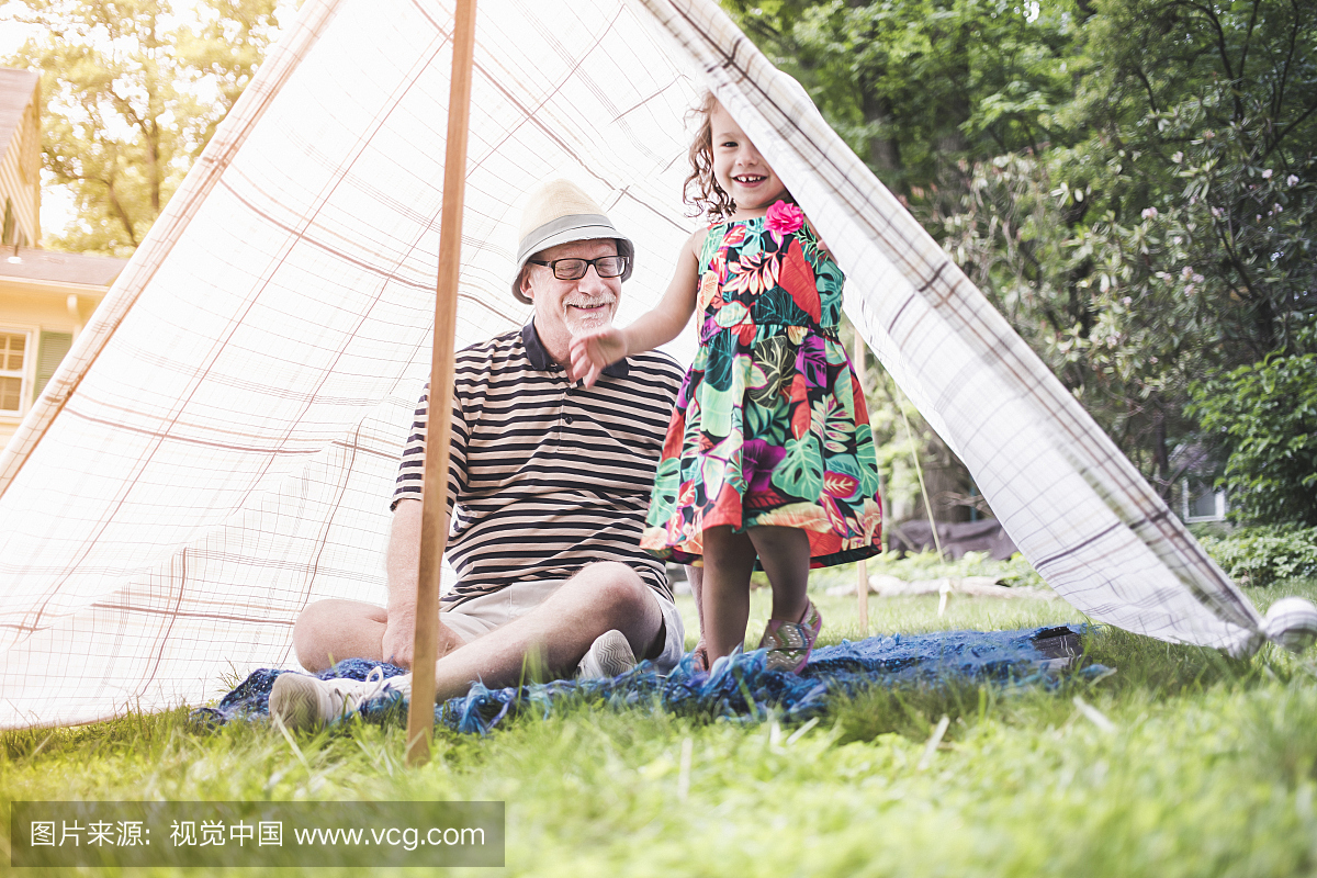 从自制的花园帐篷偷看的女孩和祖父的肖像
