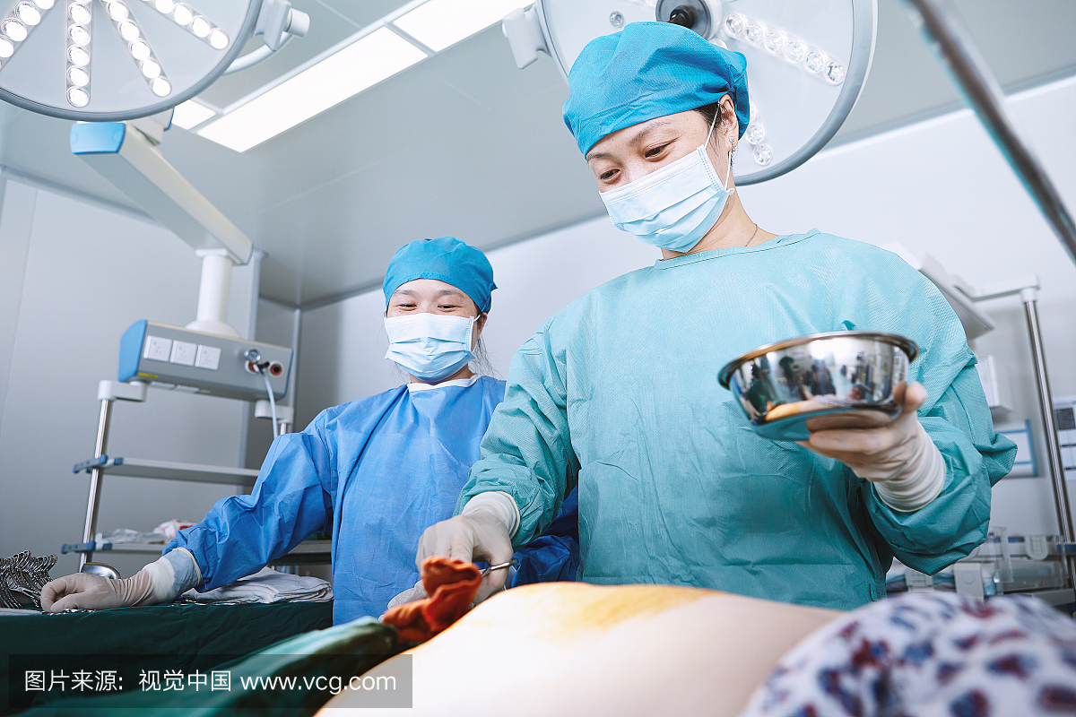 外科医生在产科病房手术室擦拭患者腹部