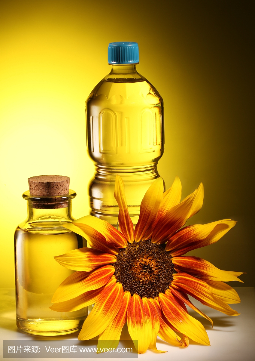 用塑料和玻璃瓶烹调油与向日葵。