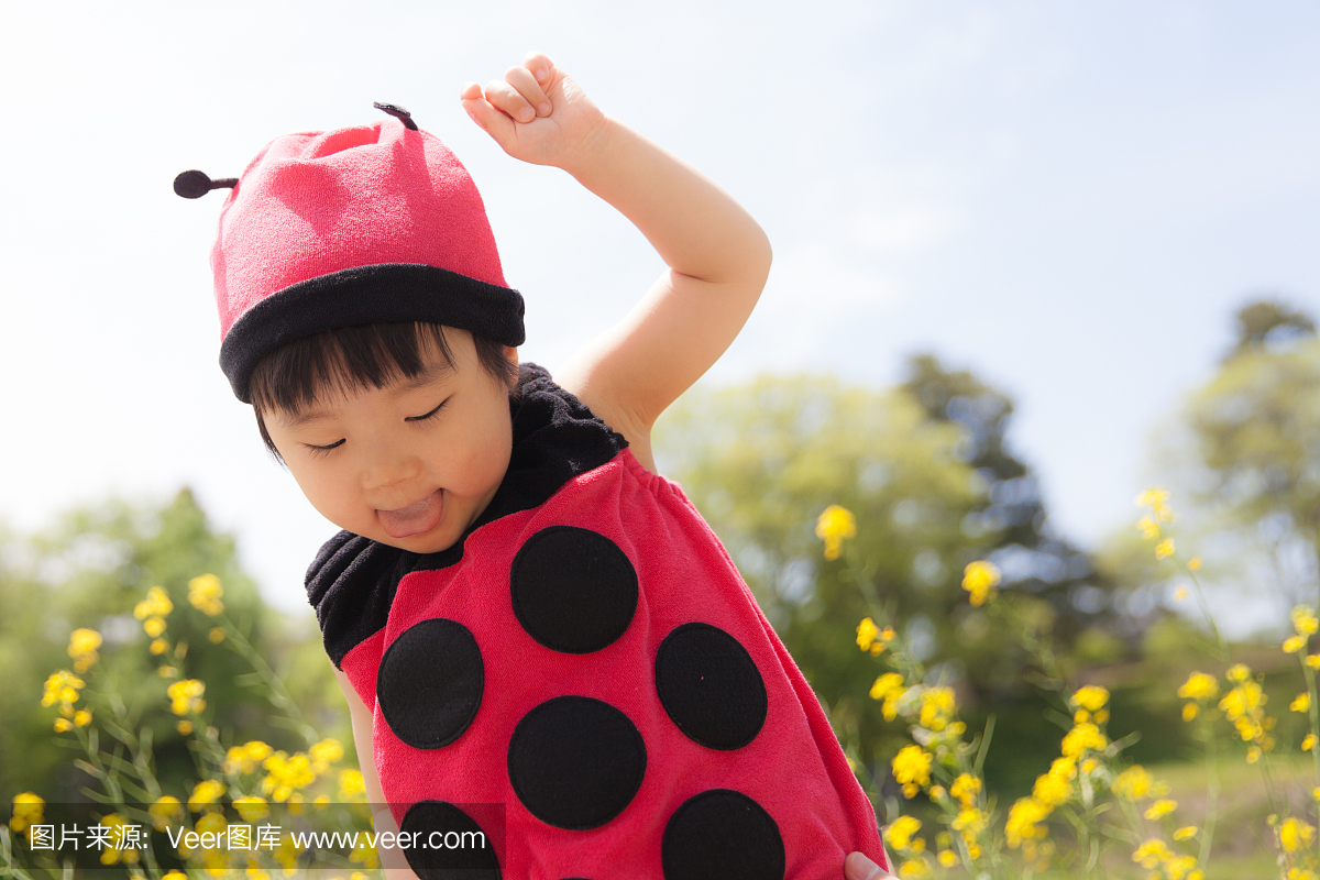 在瓢虫衣服上飞过花园的日本女婴