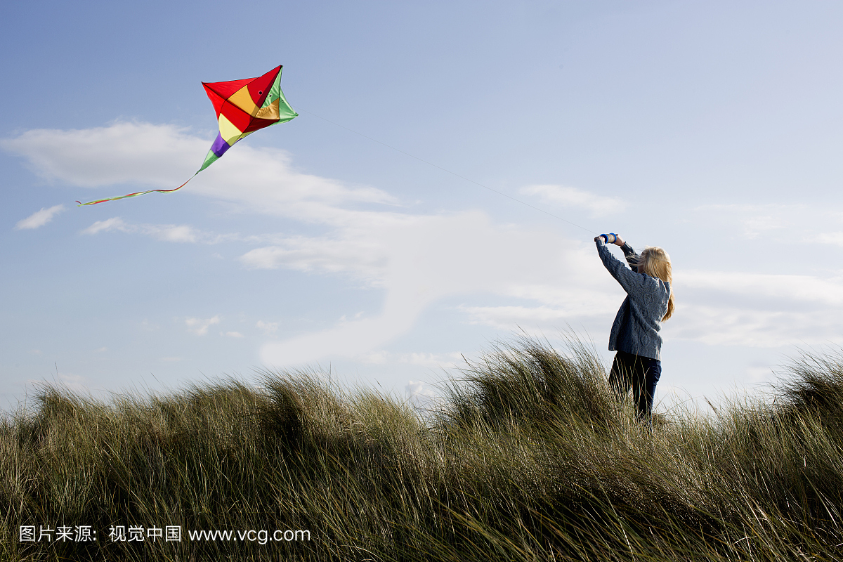 十几岁的女孩在海滩上放风筝。