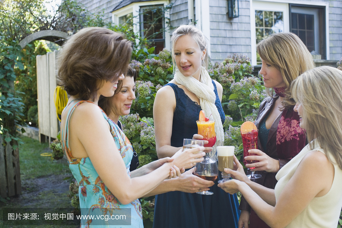 五位女士在花园聚会中品尝饮料
