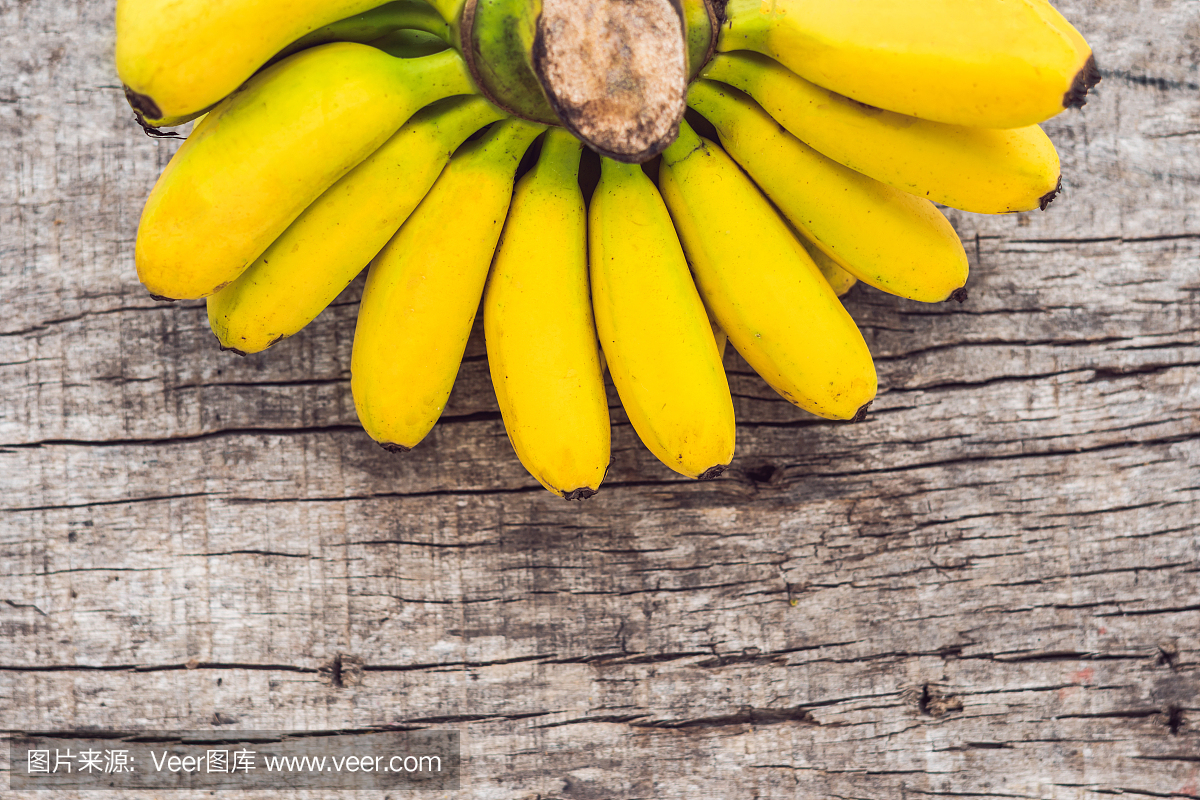 束在木背景的未加工的成熟有机黄色香蕉