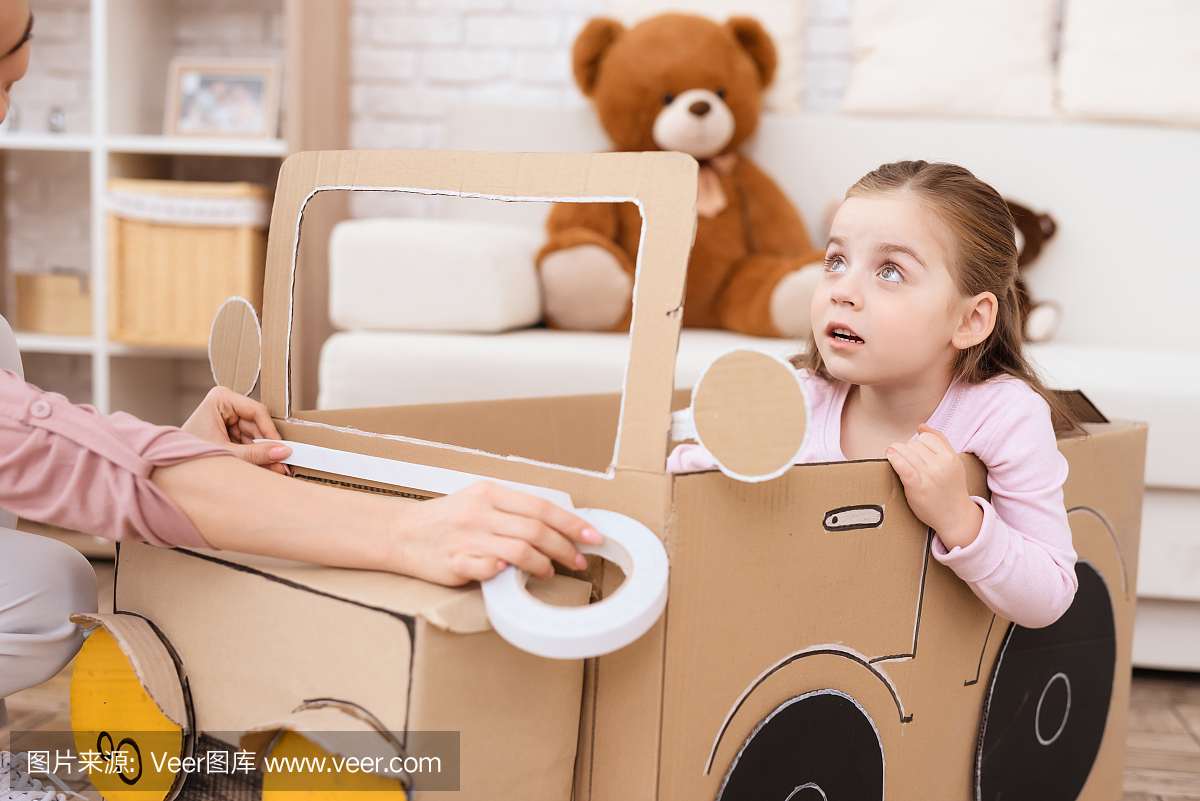 一位小女孩和她的母亲正在玩玩具车。