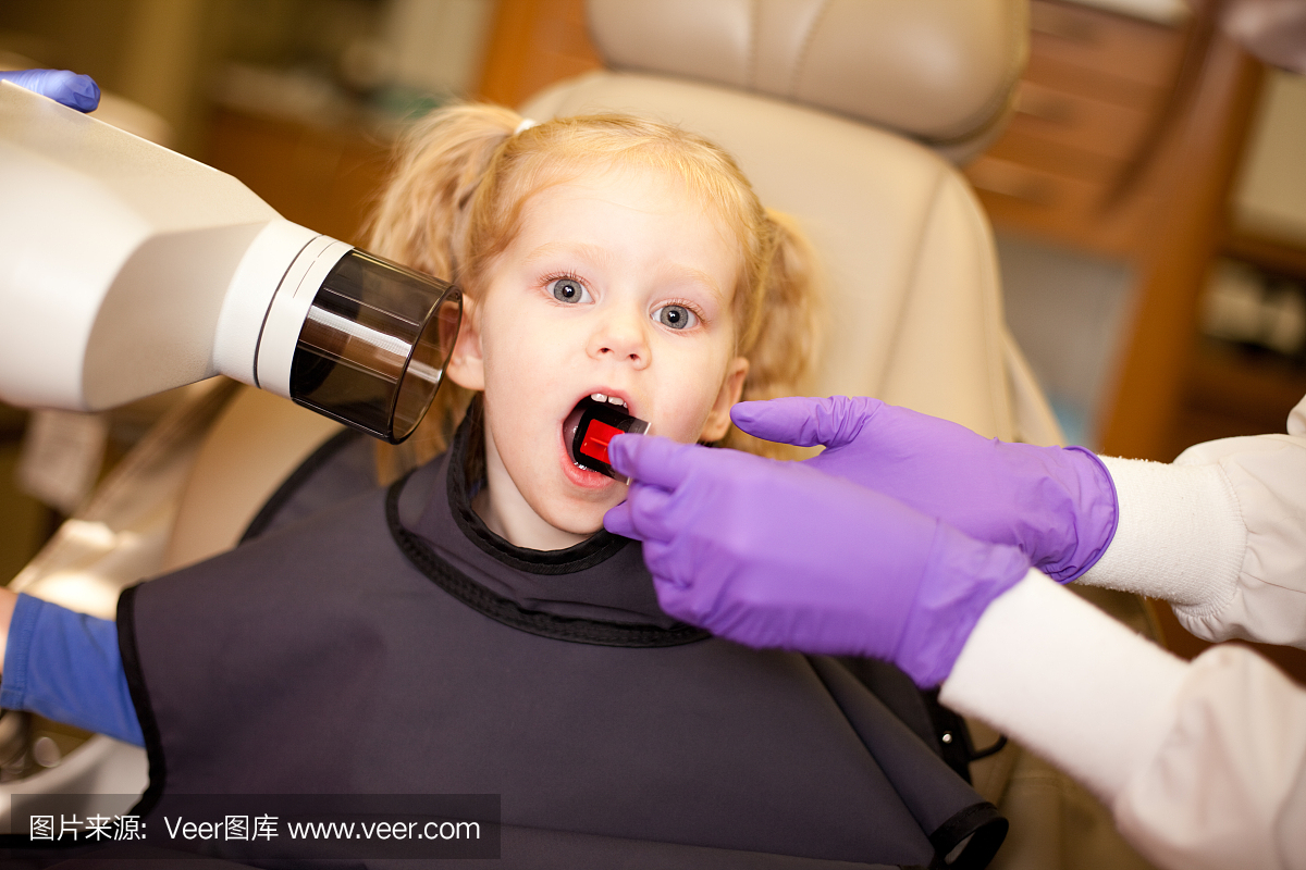 小女孩在牙科诊所用牙医X光照射牙齿