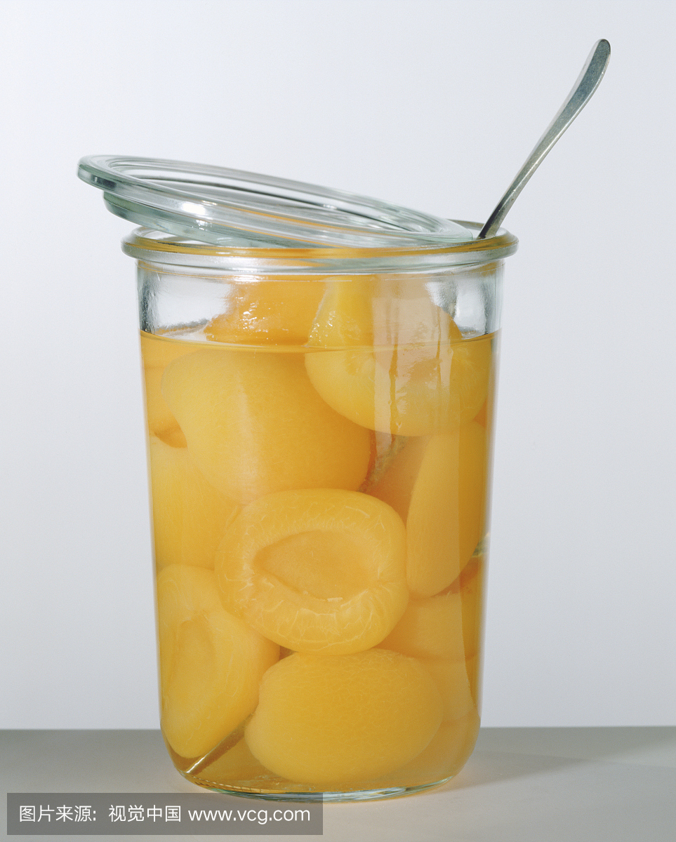 桃子保存在罐中反对白色背景,特写