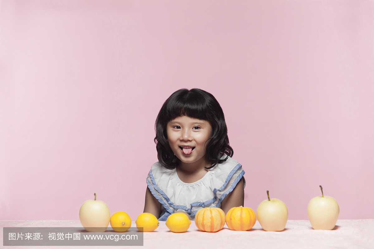 吐舌头的小女孩与桌上的果蔬