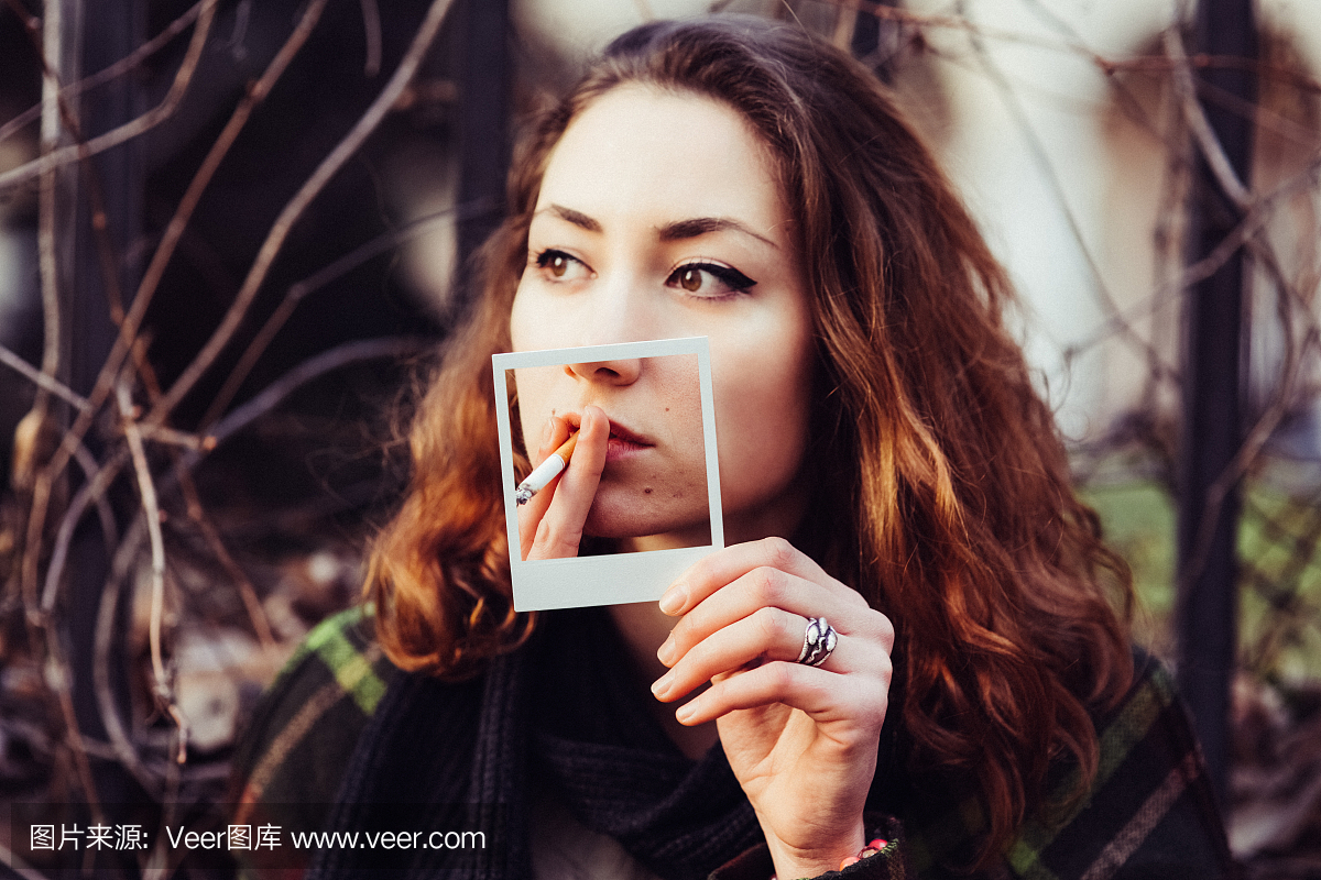 吸烟者持有即时照片,显示吸烟对皮肤的伤害