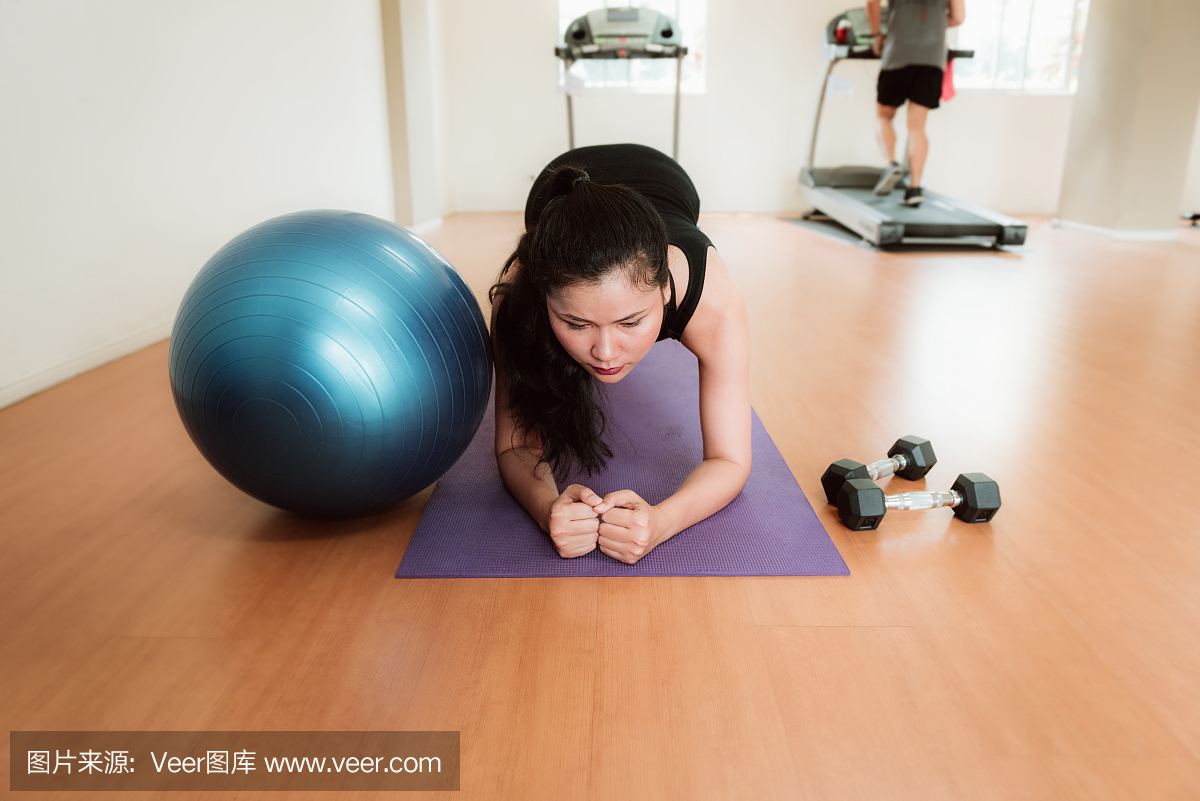 斑点的女人,行使与瑜伽球在健身房里的肖像