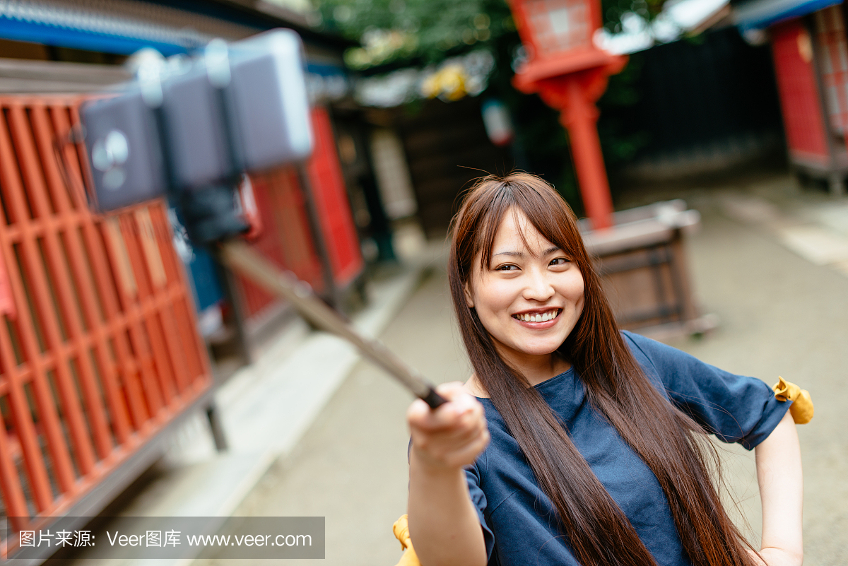 日本年轻美丽的女人为自己的社交媒体采取自我