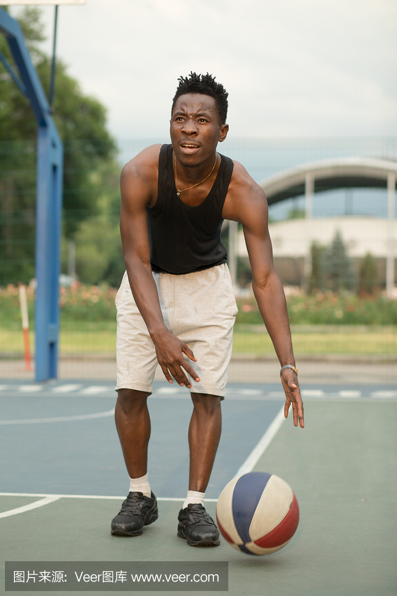 在篮球场上的非洲裔美国人运球与球。真实和真
