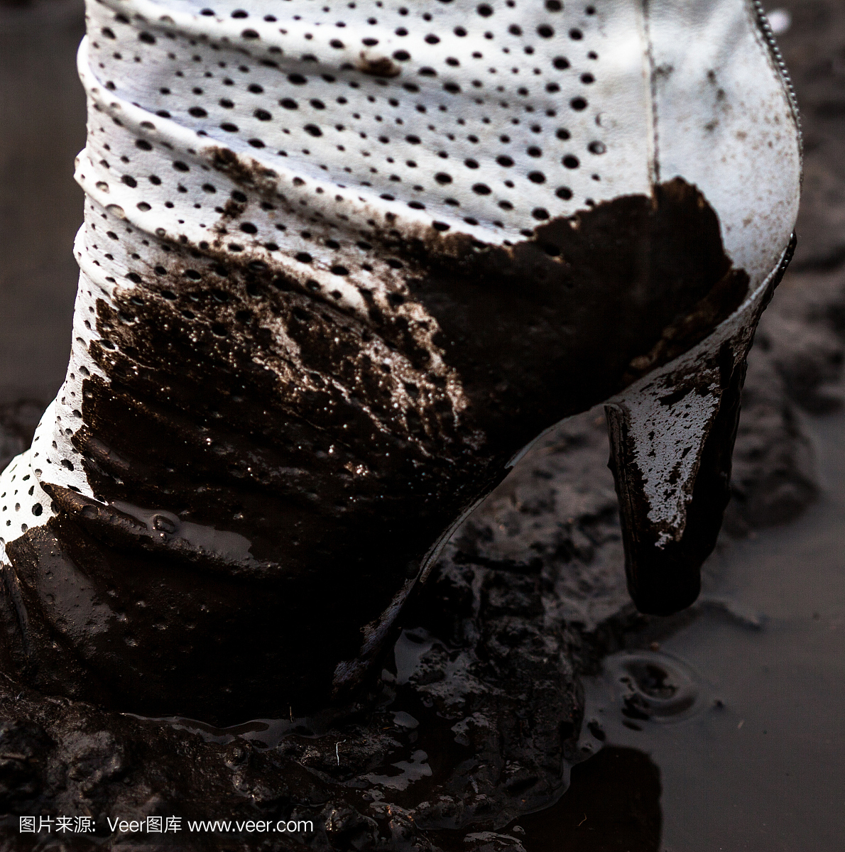 肮脏的白色高跟鞋在泥里
