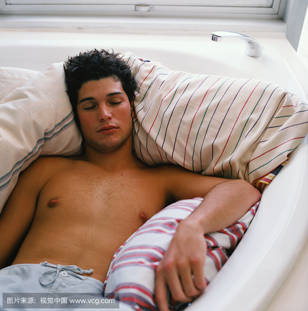 一个年轻人高高的看法,睡在一个浴缸中的羽绒