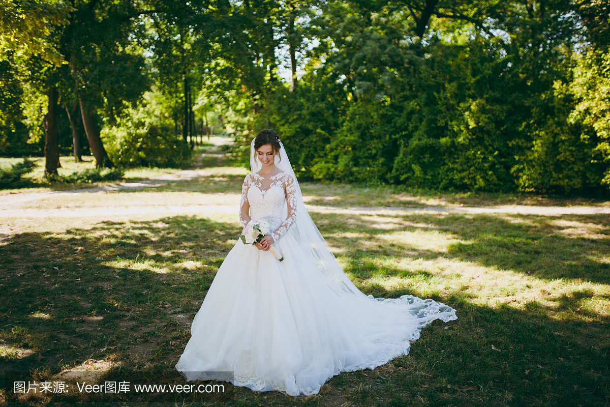 婚礼photosession。白色蕾丝礼服的新娘在长的