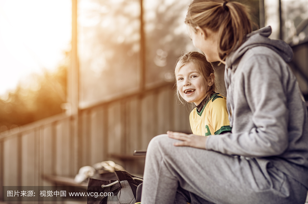 年轻的金发女子足球教练和她的女孩足球队