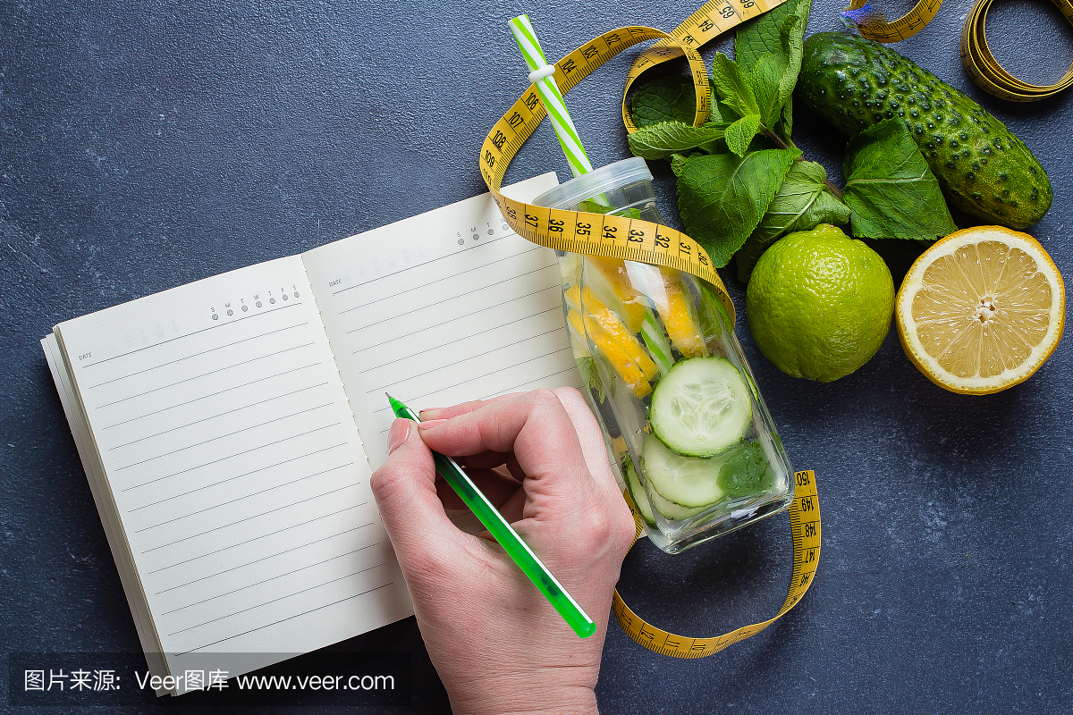 女人写营养计划饮食菜单和健身锻炼日常工作。