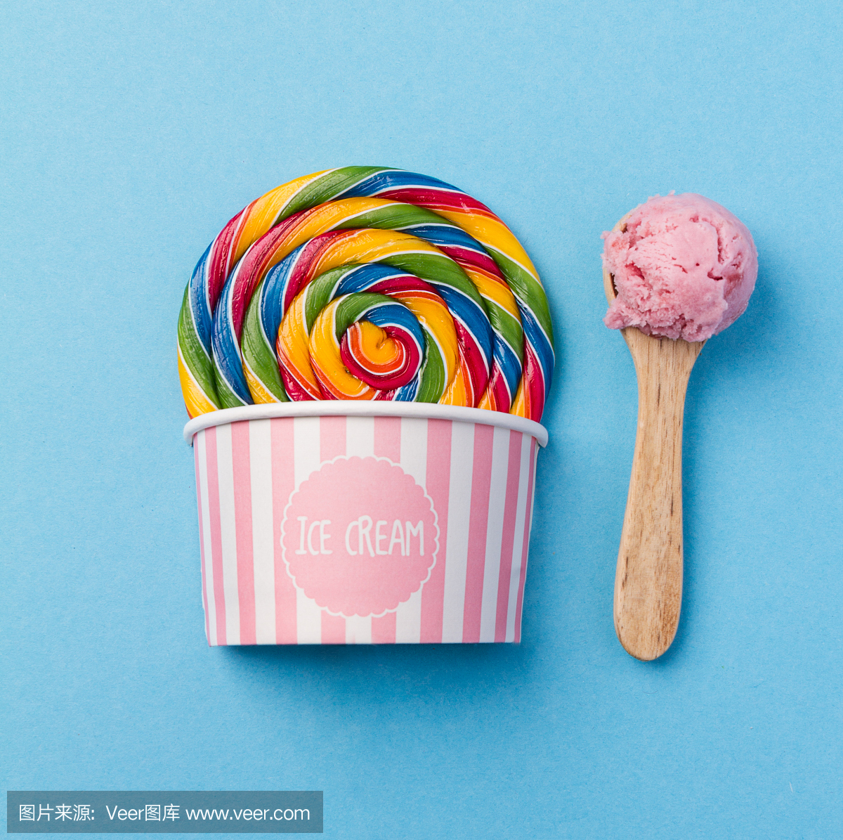 美味开胃假的棒棒糖冰淇淋在粉红色的纸杯在蓝
