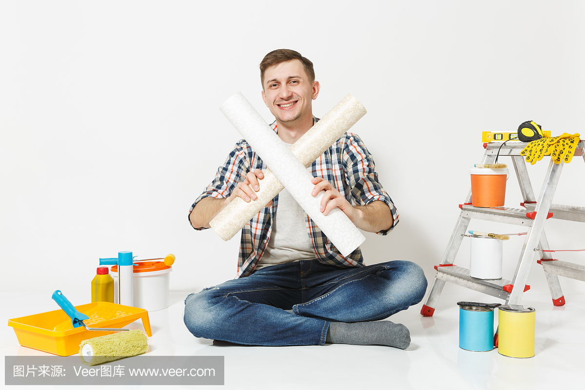 穿休闲服坐在地板上与交叉卷的壁纸,仪器为孤