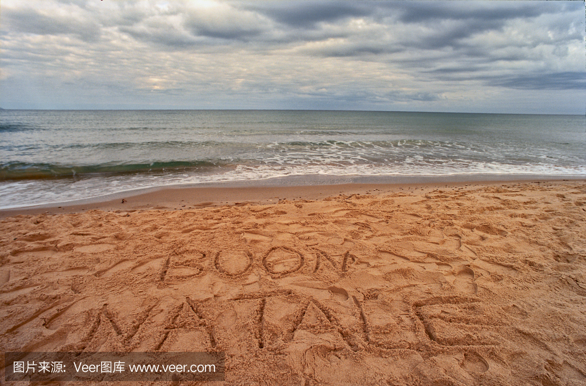 圣诞快乐用意大利语写在沙滩上