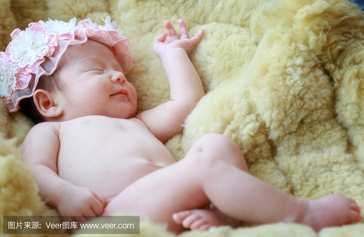 刚出生的婴儿女孩在梦中微笑,初生女婴睡在毛
