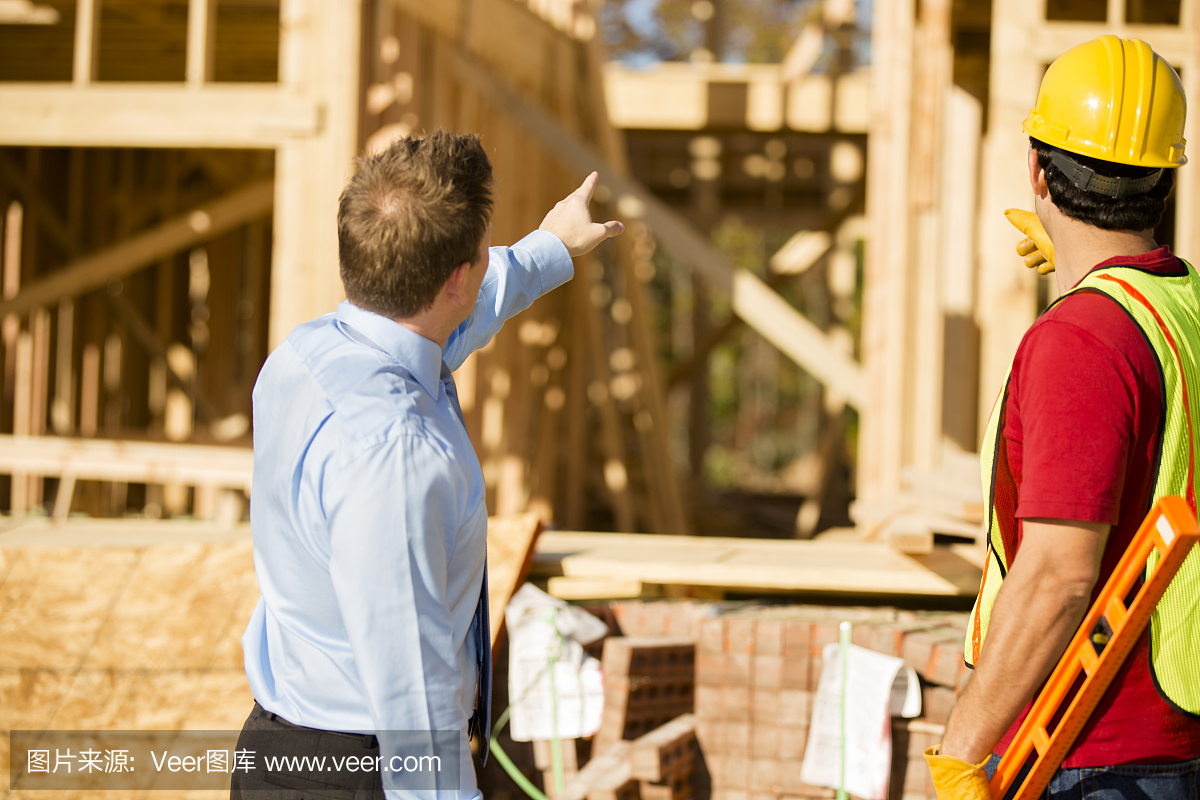 建筑工人,房地产开发商在工作现场讨论工作。