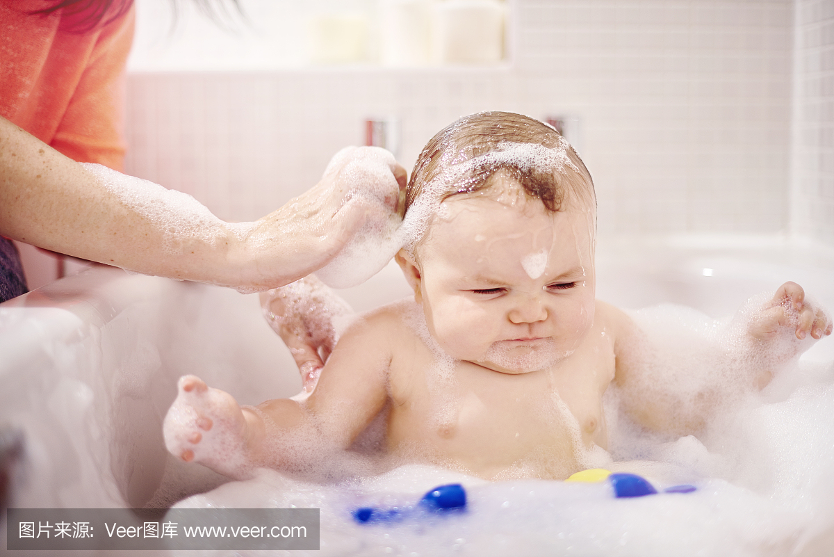 男婴坐在浴缸里洗头发