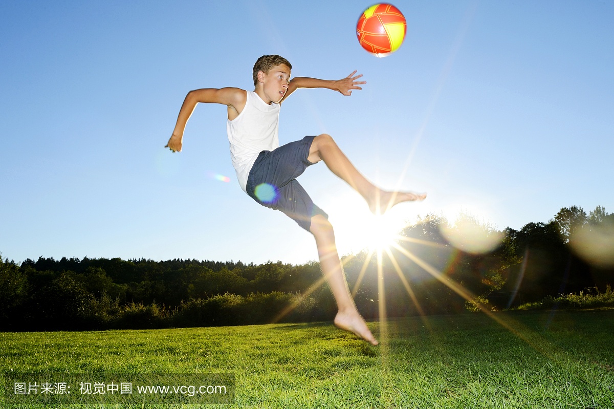 德国男孩(12-13岁)在草地上踢足球