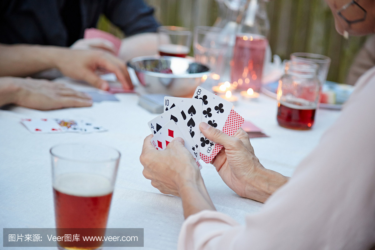 朋友玩纸牌游戏在花园聚会