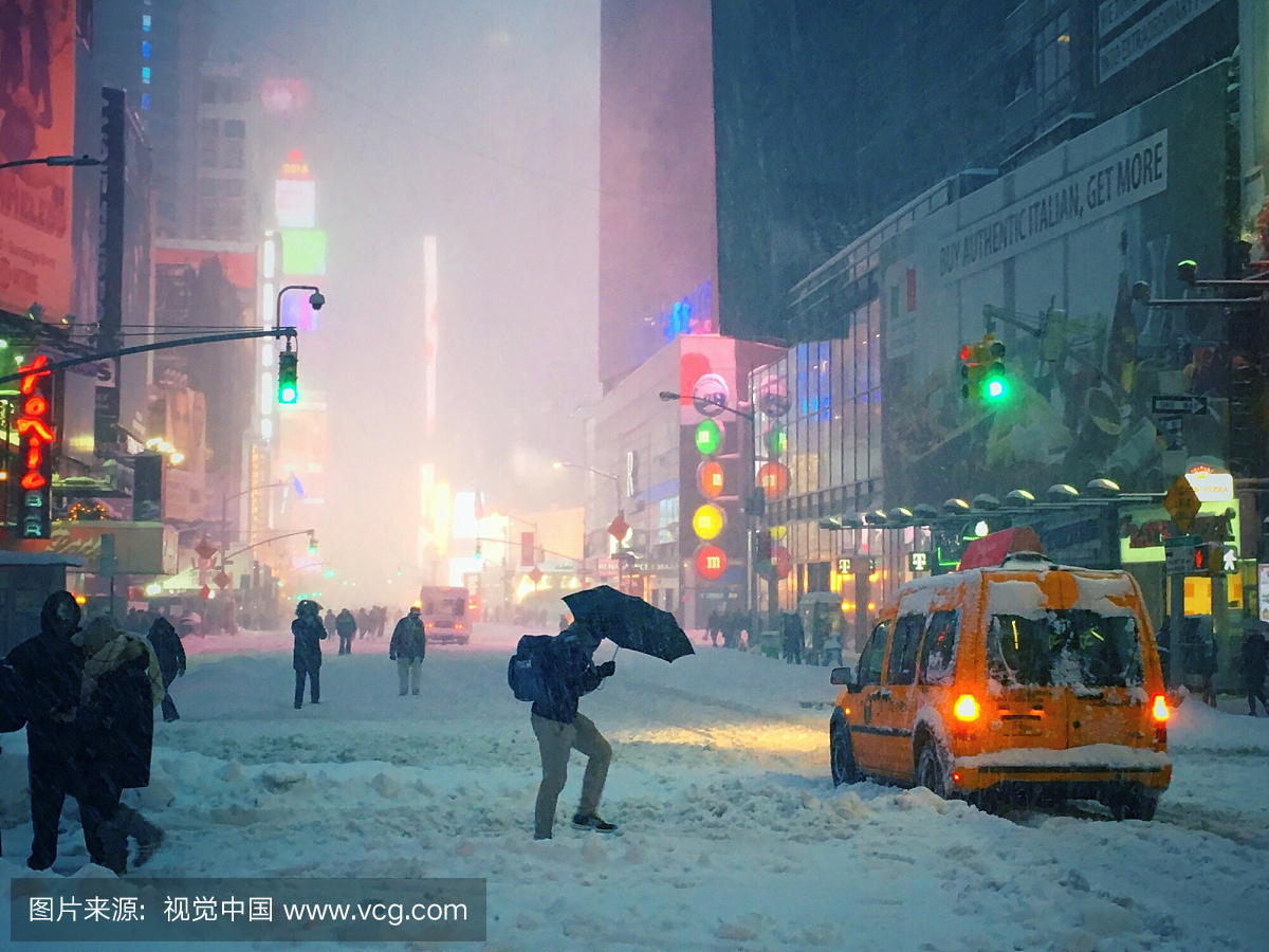 雨伞的男子在2016年风雪期间穿过时代广场积