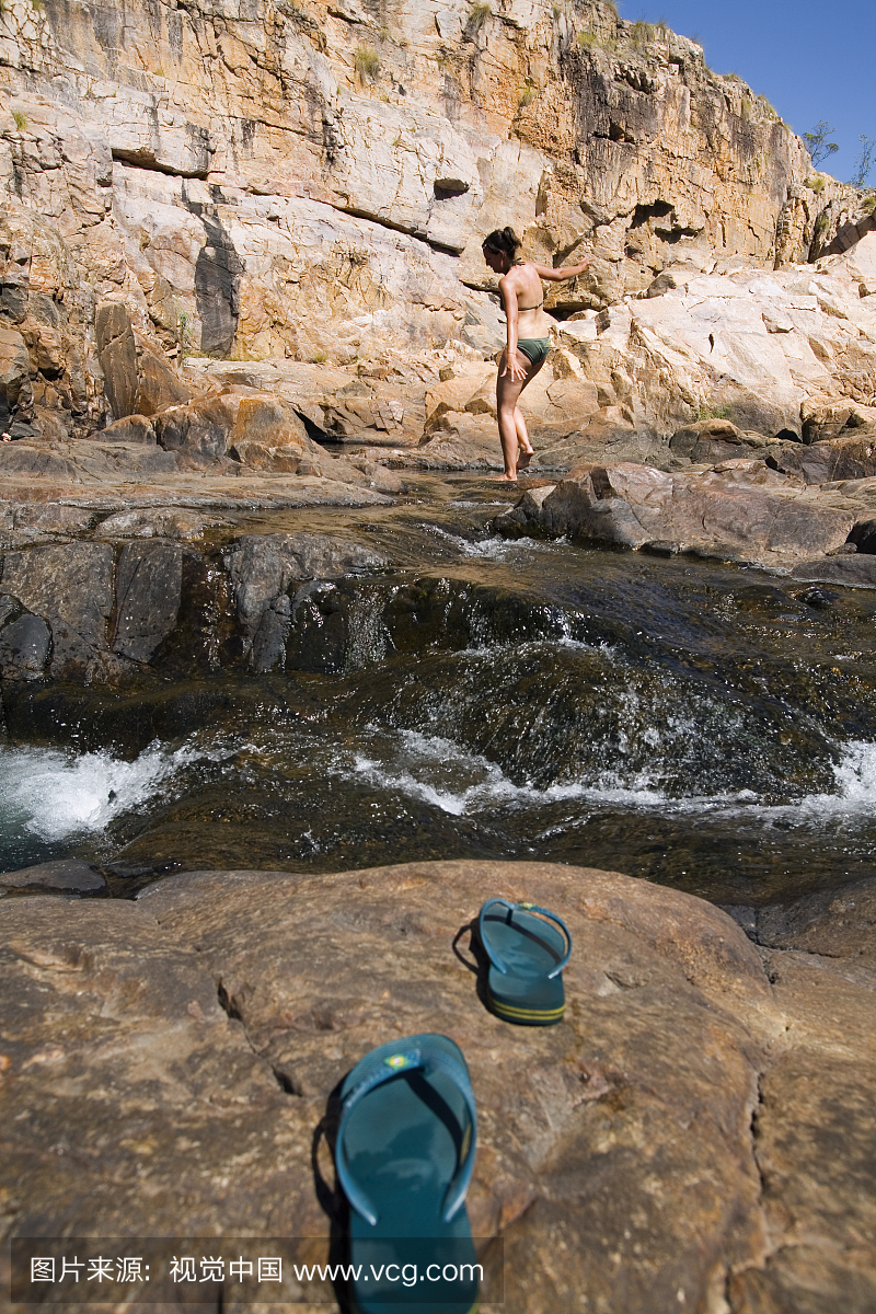 在Maguk(Barramundi峡谷)的自然水池游泳的女