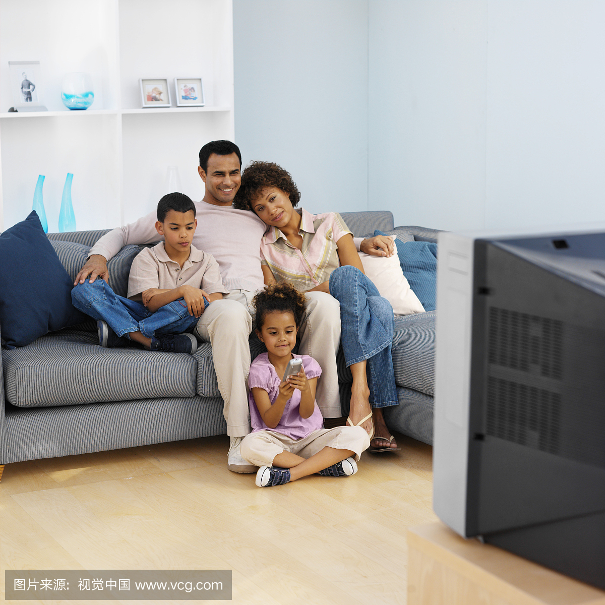 家长和两个孩子看电视的前视图(9-11)
