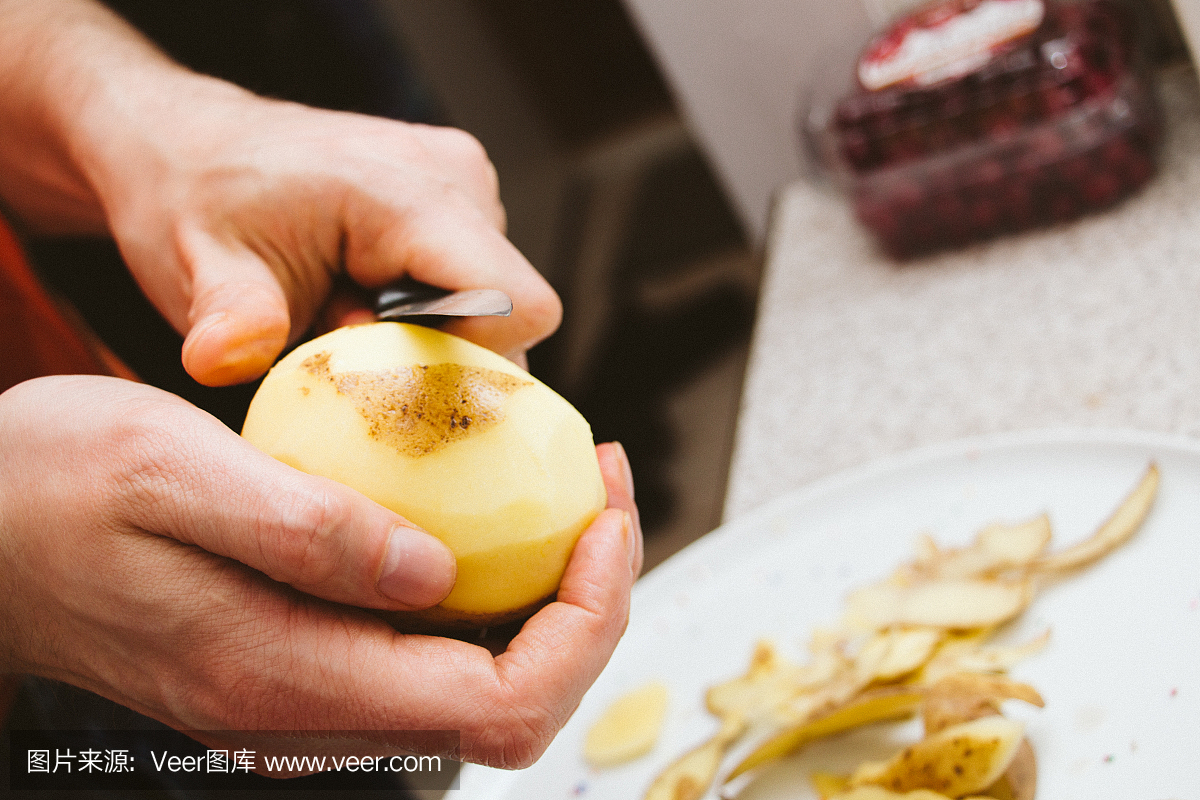 Close up of man's hands who peels potatoes fr