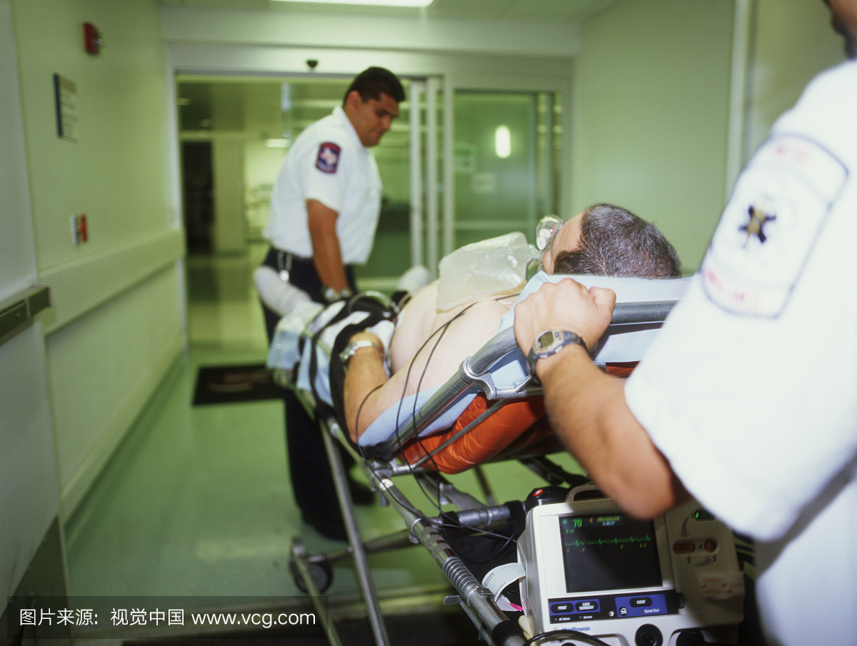 男病人被两名男子在医院的床上轮转