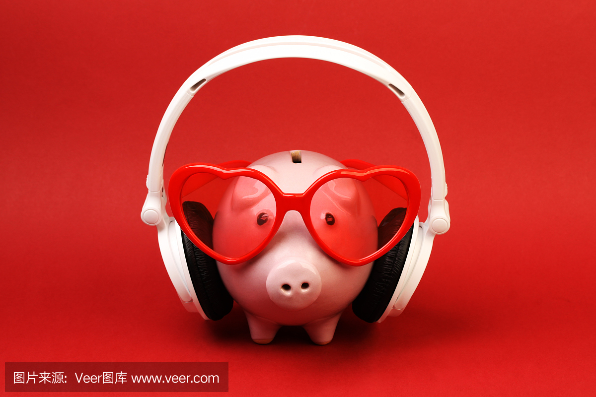 与红色的心太阳镜和红色背景上的耳机的小猪爆